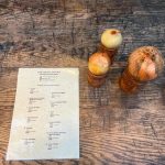Laminated catalogue ready for visitor browsing on a table with some onions