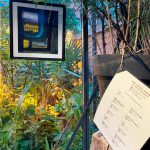 Laminated catalogue list hung in The Onion Garden with hung artwork