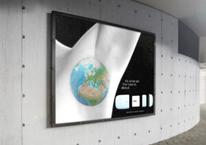 A concrete industrial wall showcasing a poster of the Fussy deodorant brand featuring a colourful illustration of planet earth tattooed on a black-and-white armpit.